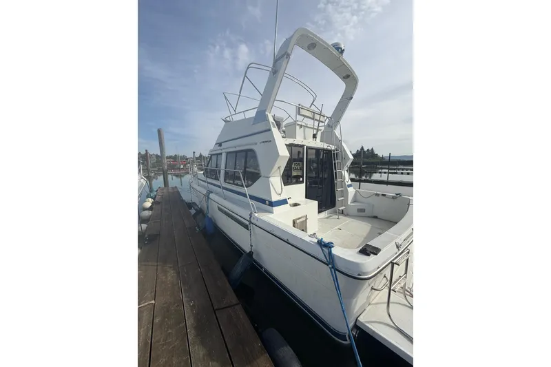 Slide: The Image of 1990 Cooper Prowler boat docked, white exterior, for sale sign visible. - 3