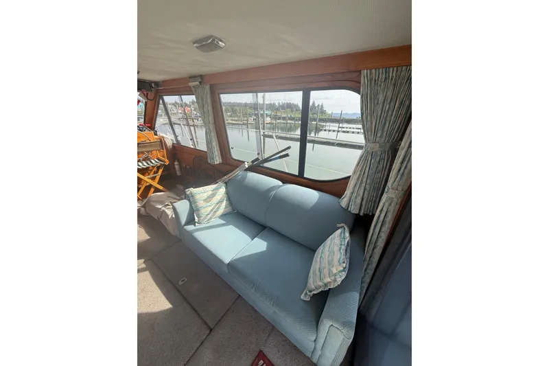 Slide: The Image of Interior of 1990 Cooper Prowler boat with blue sofa and marina view. - 7