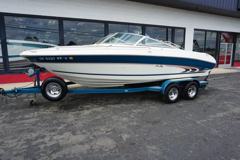 The Image of 1998 Sea Ray 210 Signature boat on trailer outside store. - 1