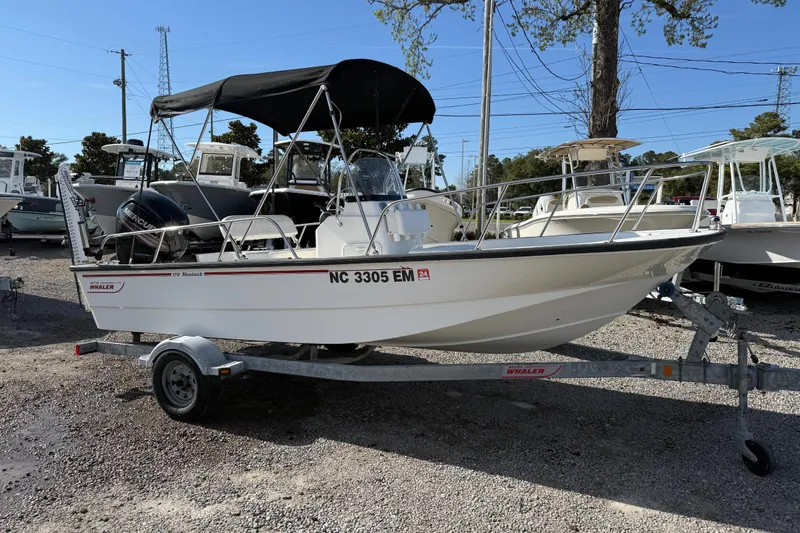 Slide: The Image of 2015 Boston Whaler 170 Montauk boat on trailer, parked outdoors under clear sky. - 5