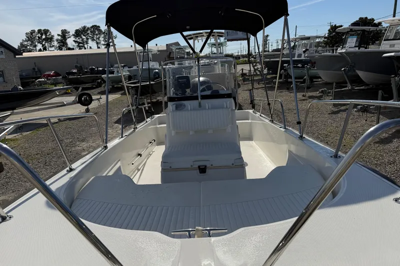 Slide: The Image of 2015 Boston Whaler 170 Montauk boat with canopy, displayed outdoors in a marina setting. - 9