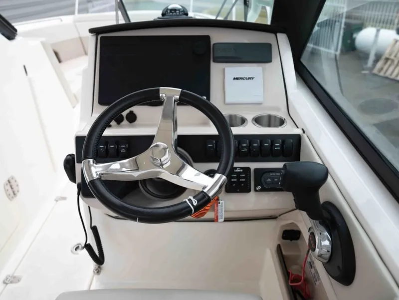 Slide: The Image of 2022 Boston Whaler 240 Vantage helm with steering wheel and controls. - 12