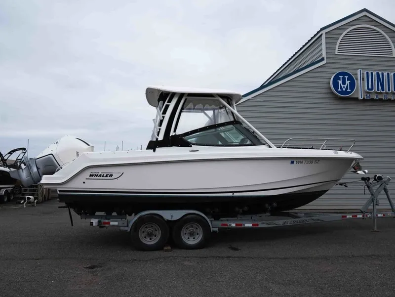 Slide: The Image of 2022 Boston Whaler 240 Vantage on trailer outside a building. - 2