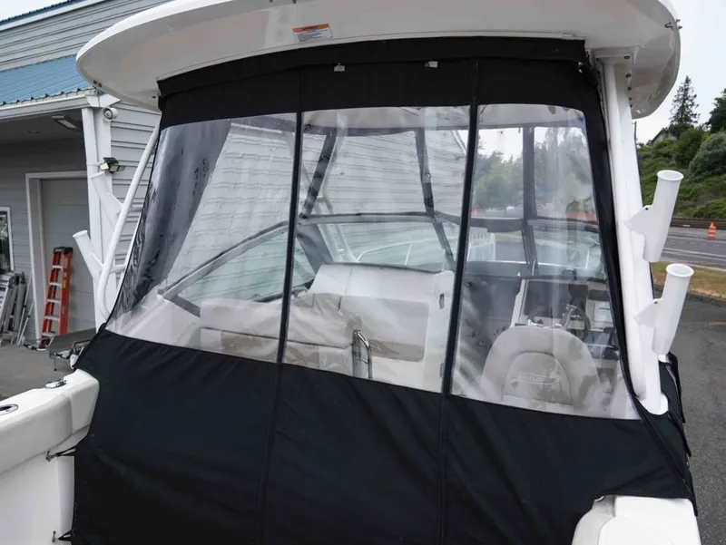 Slide: The Image of 2022 Boston Whaler 240 Vantage with black cover and clear windows. - 6