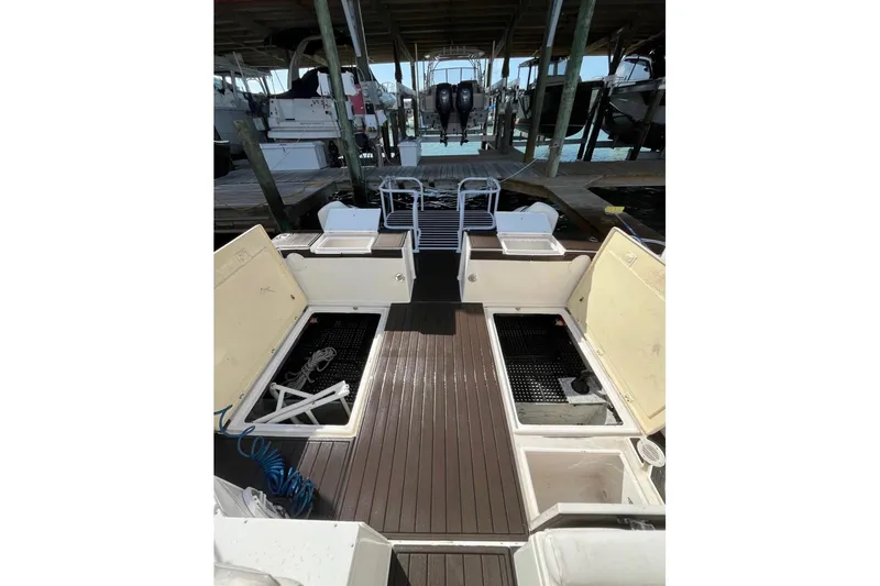 Slide: The Image of 2008 ProKat 3660 Sport Fish boat interior with open storage compartments and dock view. - 11