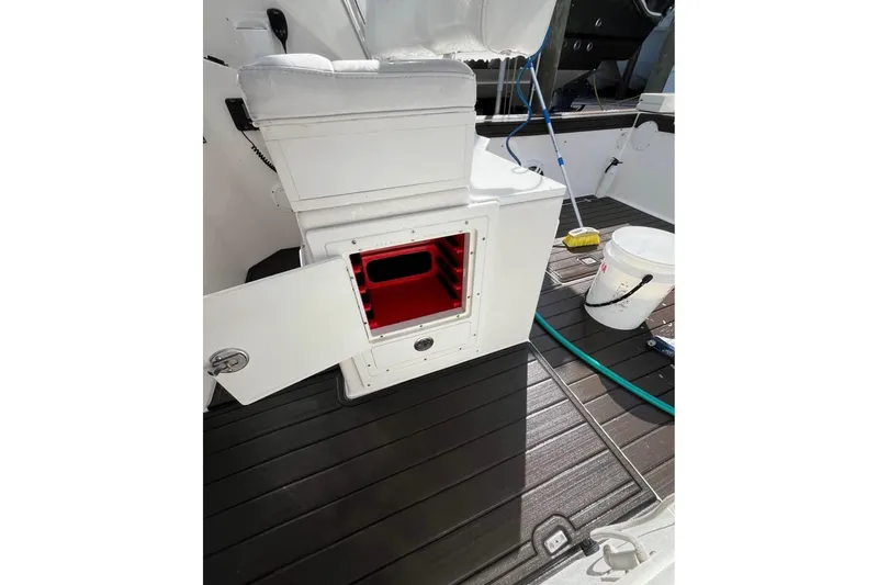 Slide: The Image of 2008 ProKat 3660 Sport Fish boat interior with open storage compartment and cleaning supplies. - 16