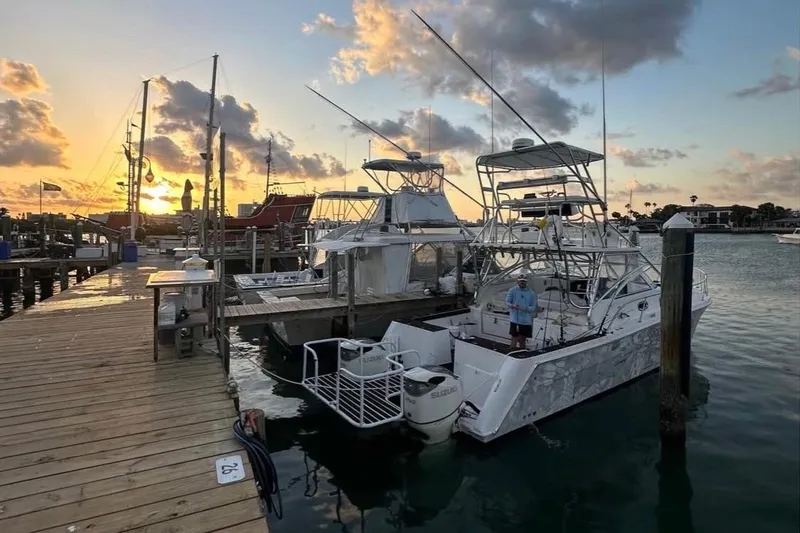 Slide: The Image of 2008 ProKat 3660 Sport Fish boat docked at sunset with scenic harbor view. - 3