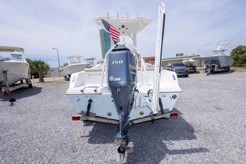 Slide: The Image of 2015 Sportsman Heritage 211 Center Console boat with Yamaha 150 engine, parked outdoors. - 11