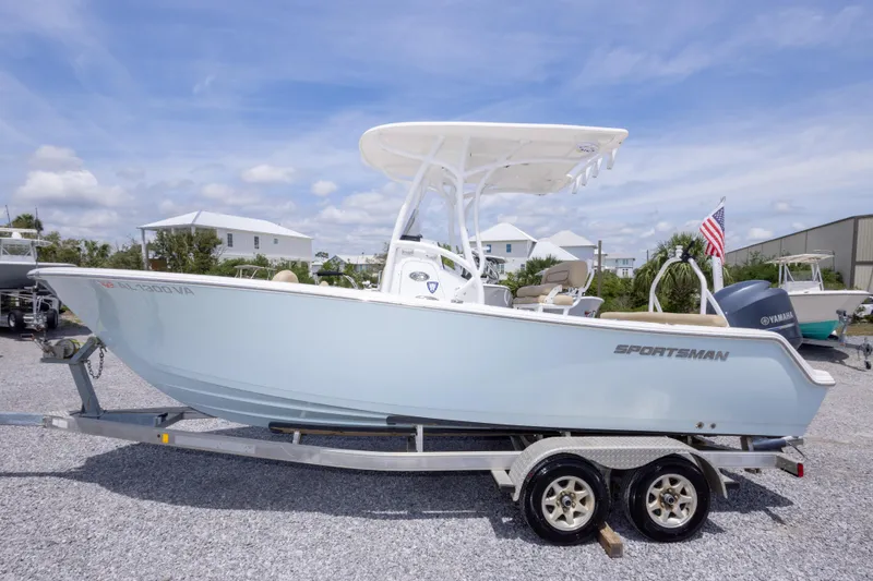 Slide: The Image of 2015 Sportsman Heritage 211 Center Console boat on trailer, under clear blue sky. - 13