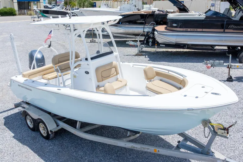 Slide: The Image of 2015 Sportsman Heritage 211 Center Console boat on trailer in a marina. - 2