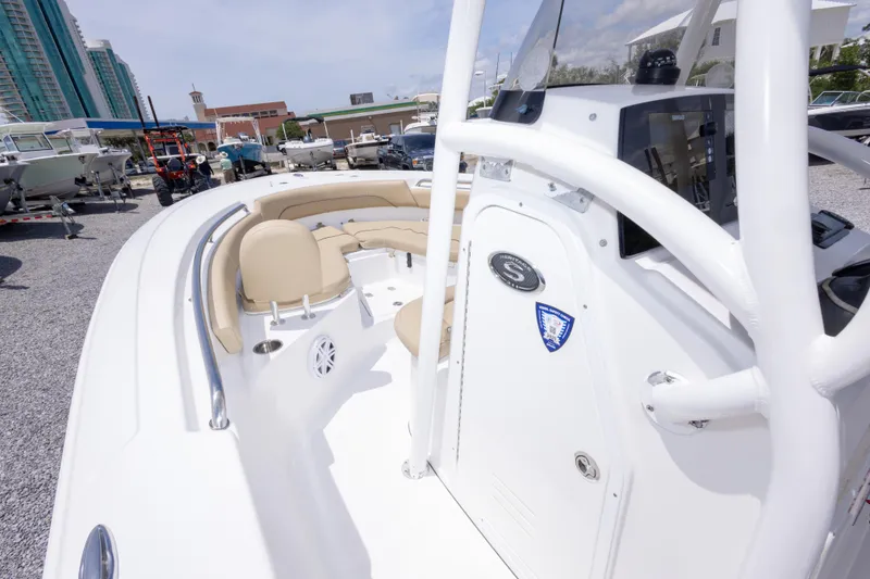Slide: The Image of 2015 Sportsman Heritage 211 Center Console boat with beige seating, displayed outdoors. - 30