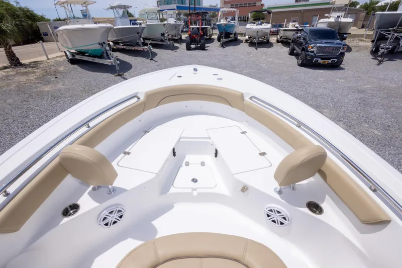 Slide: The Image of 2015 Sportsman Heritage 211 Center Console boat with beige seating, parked among other boats. - 35