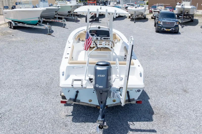 Slide: The Image of 2015 Sportsman Heritage 211 Center Console boat with Yamaha 150 engine, parked on gravel. - 43