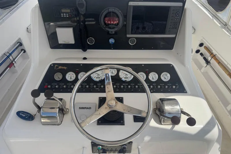 Slide: The Image of Control panel of a 2006 Strike 29 CC boat with steering wheel and gauges. - 13