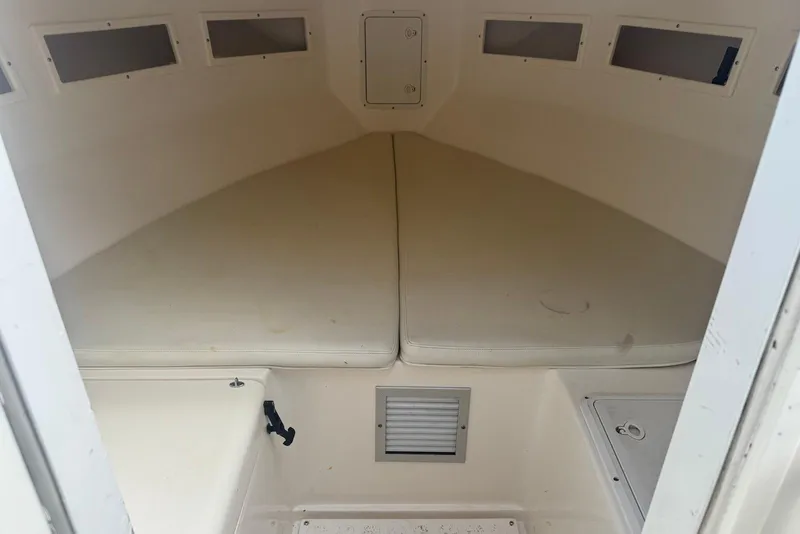 Slide: The Image of 2006 Strike 29 CC boat cabin interior with cushioned seating and storage compartments. - 14