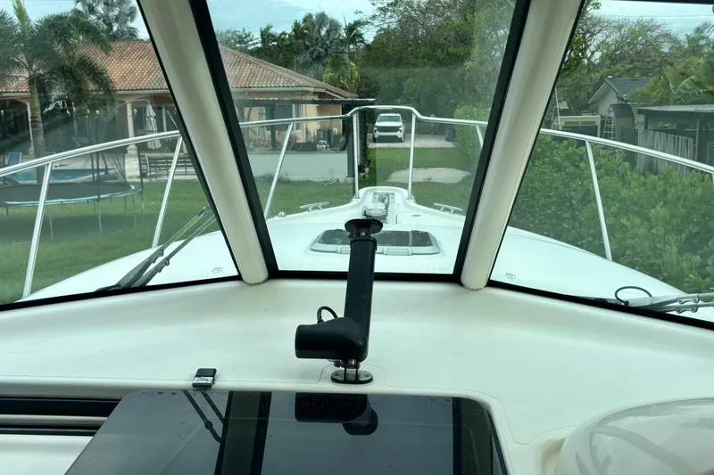 Slide: The Image of 2007 Pursuit 3370 Offshore boat interior view through windshield, showing residential background. - 10