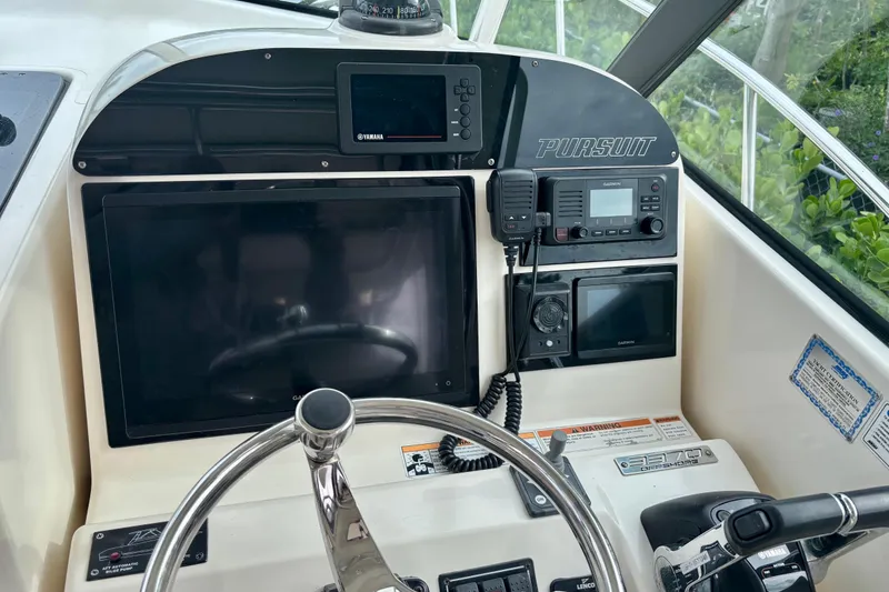 Slide: The Image of 2007 Pursuit 3370 Offshore boat dashboard with steering wheel and navigation equipment. - 14