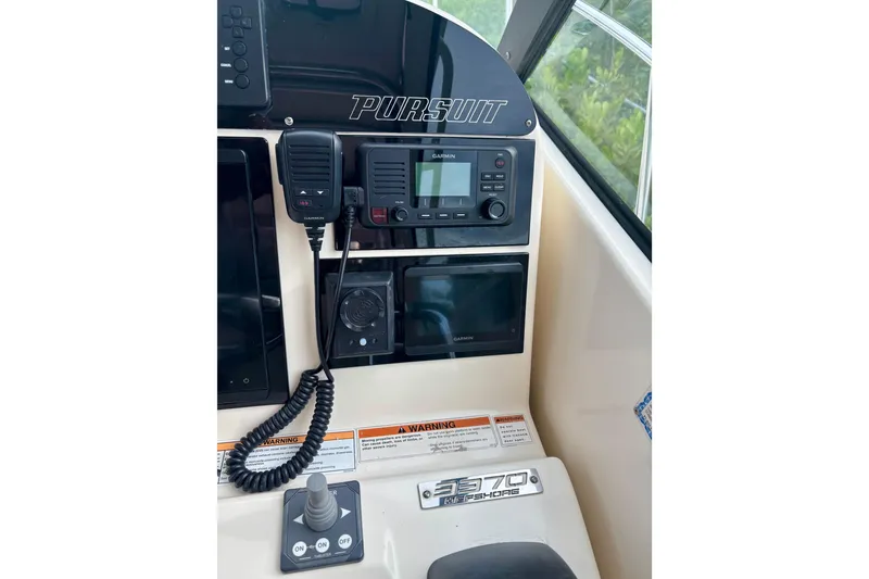 Slide: The Image of 2007 Pursuit 3370 Offshore boat dashboard with Garmin electronics and communication equipment. - 16