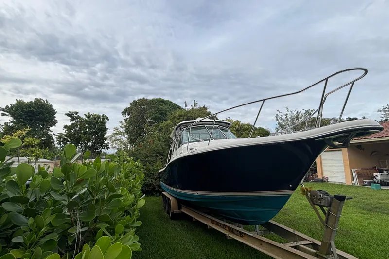 Slide: The Image of 2007 Pursuit 3370 Offshore boat on trailer, surrounded by greenery and cloudy sky. - 20