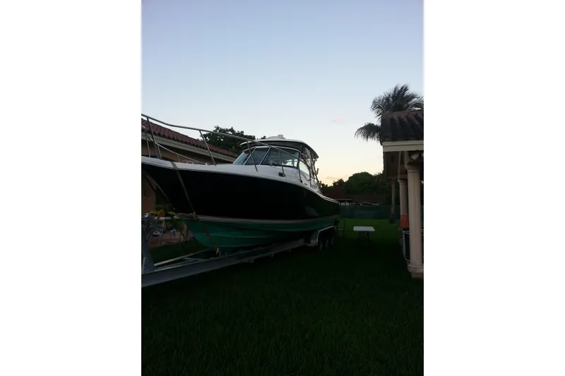 Slide: The Image of 2007 Pursuit 3370 Offshore boat on trailer in a residential yard at sunset. - 21
