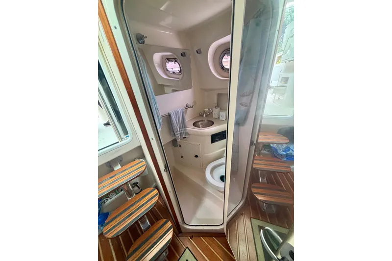 Slide: The Image of 2007 Pursuit 3370 Offshore boat bathroom with sink, toilet, and wooden steps. - 4