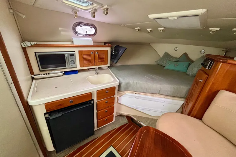 Slide: The Image of Interior of 2007 Pursuit 3370 Offshore boat with kitchenette and cozy sleeping area. - 5