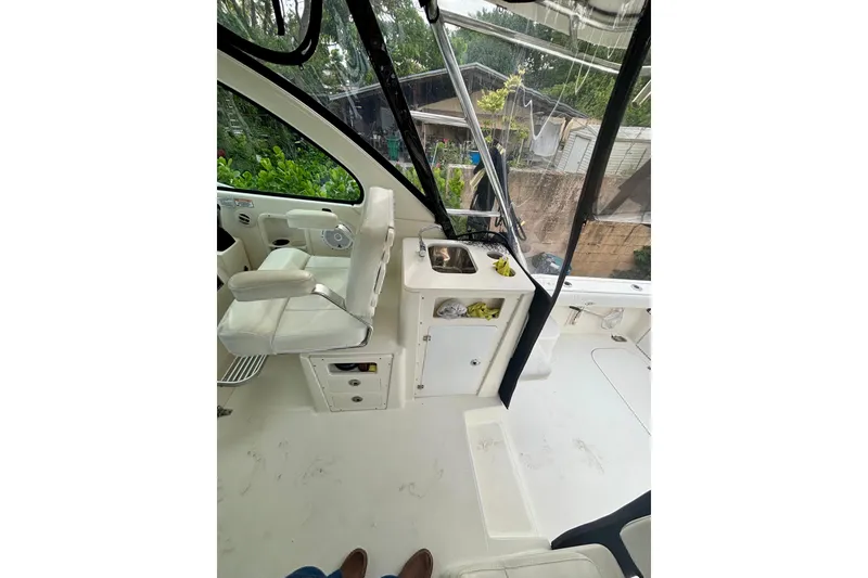 Slide: The Image of 2007 Pursuit 3370 Offshore boat interior with white seating and compact sink area. - 8