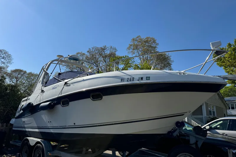 Slide: The Image of 2004 Four Winns 268 Vista boat on trailer, parked outdoors under clear blue sky. - 11