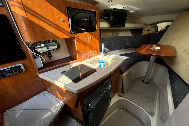 Slide: The Image of Interior of 2004 Four Winns 268 Vista boat with kitchenette and seating area. - 16