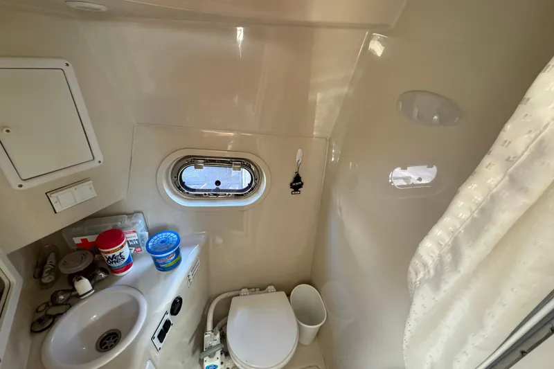 Slide: The Image of 2004 Four Winns 268 Vista boat bathroom with sink, toilet, and porthole window. - 19