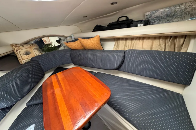 Slide: The Image of Interior of 2004 Four Winns 268 Vista boat with cushioned seating and wooden table. - 4