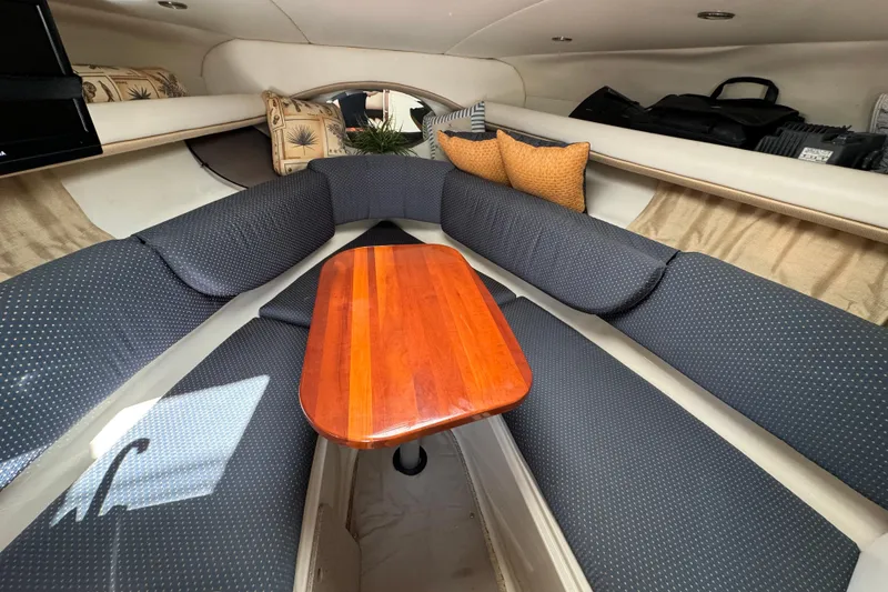 Slide: The Image of Interior of 2004 Four Winns 268 Vista boat with cushioned seating and wooden table. - 6
