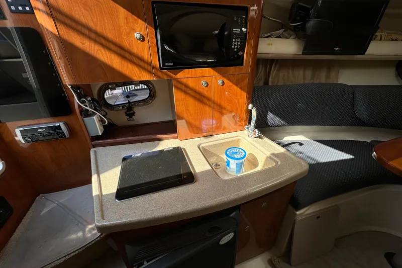 Slide: The Image of 2004 Four Winns 268 Vista cabin interior with kitchenette, microwave, and seating area. - 7