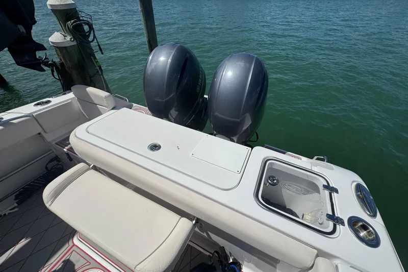 Slide: The Image of 2023 Sea Hunt Gamefish 27 boat with dual engines and seating, docked on calm water. - 10