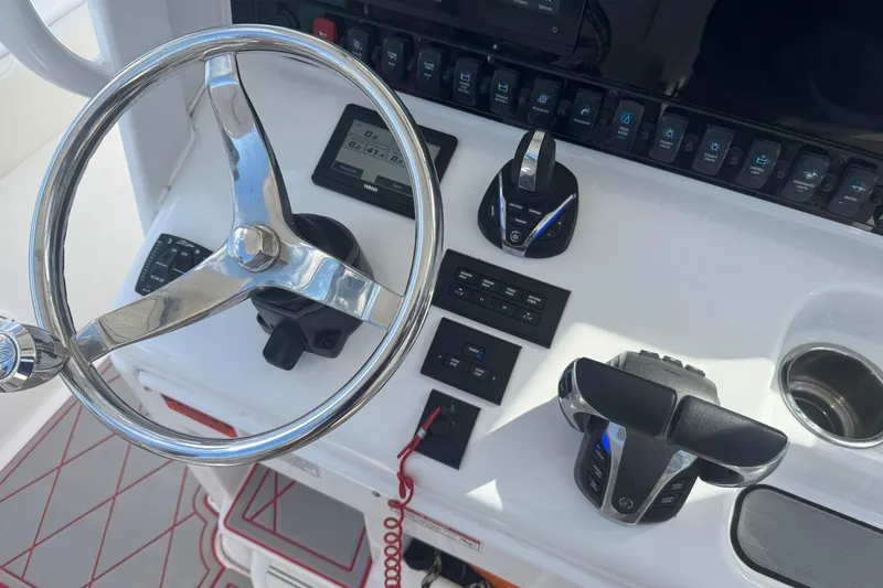 Slide: The Image of Control panel of 2023 Sea Hunt Gamefish 27 boat with steering wheel and switches. - 21