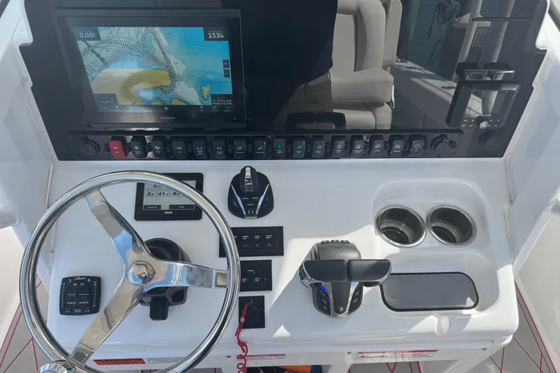 Slide: The Image of 2023 Sea Hunt Gamefish 27 dashboard with steering wheel, controls, and navigation display. - 23