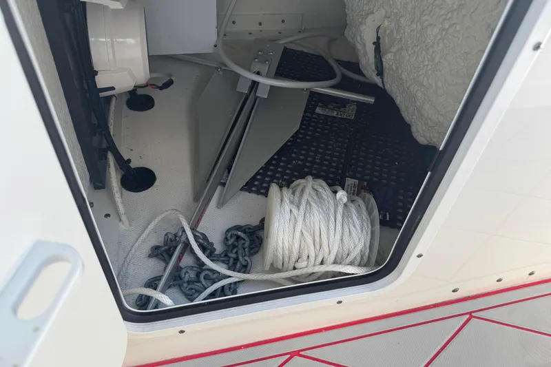 Slide: The Image of Storage compartment of 2023 Sea Hunt Gamefish 27, featuring anchor, rope, and chain. - 25