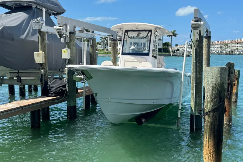 Slide: The Image of 2023 Sea Hunt Gamefish 27 boat docked on a lift in a marina. - 4