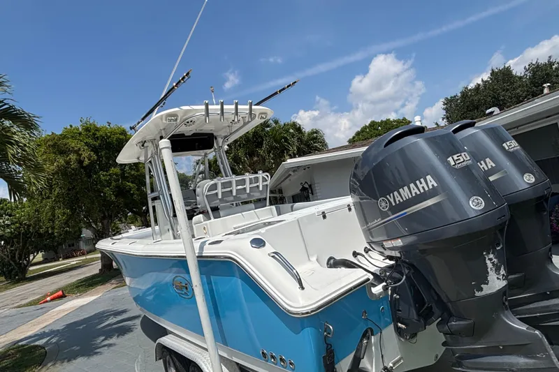 Slide: The Image of 2011 Sea Hunt Gamefish 25 boat with twin Yamaha 150 engines, parked outdoors. - 2