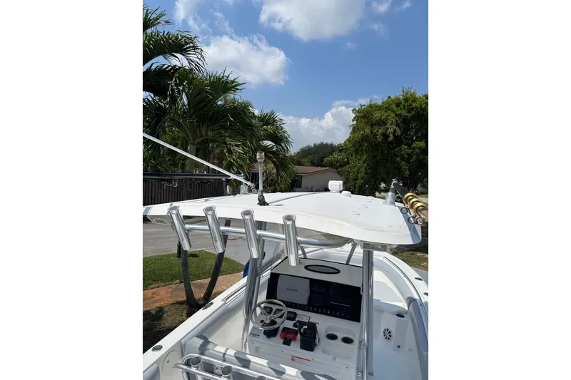 Slide: The Image of 2011 Sea Hunt Gamefish 25 boat with T-top and fishing rod holders under a clear sky. - 3
