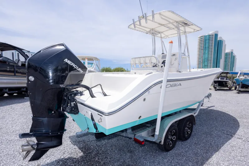 Slide: The Image of 2022 Cobia 237 Center Console boat with Mercury engine on trailer, parked outdoors. - 13