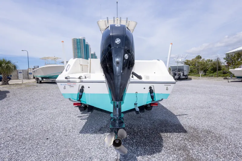 Slide: The Image of 2022 Cobia 237 Center Console boat with outboard motor, parked on gravel lot. - 14