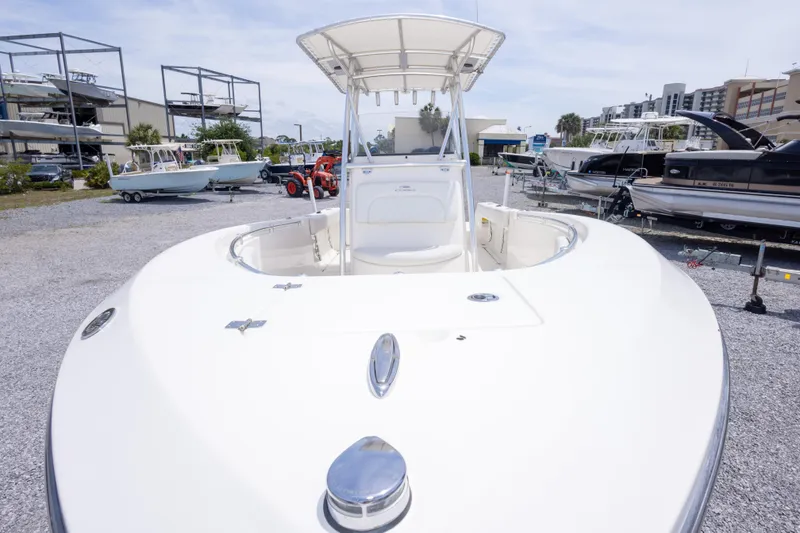 Slide: The Image of 2022 Cobia 237 Center Console boat displayed in a marina with other vessels. - 18