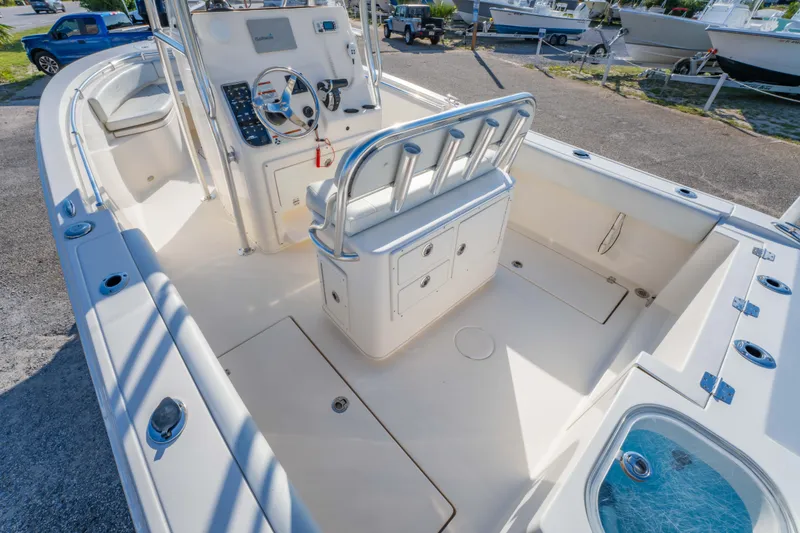 Slide: The Image of 2022 Cobia 237 Center Console boat interior with helm, seating, and storage compartments. - 23