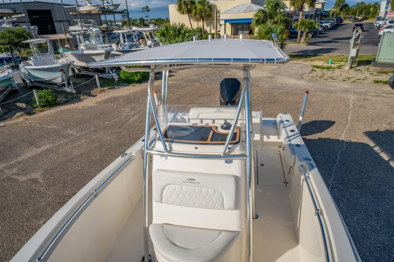 Slide: The Image of 2022 Cobia 237 Center Console boat at a marina, showcasing sleek design and spacious layout. - 34