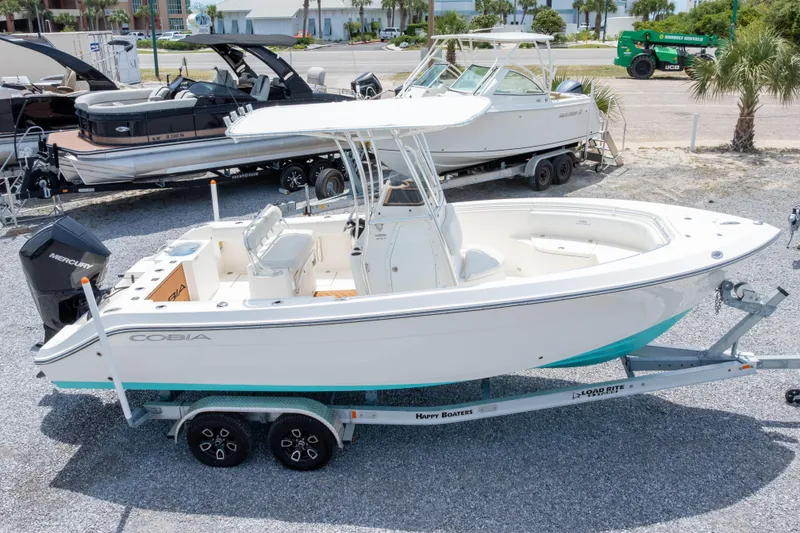 Slide: The Image of 2022 Cobia 237 Center Console boat on trailer, with a cityscape background. - 8