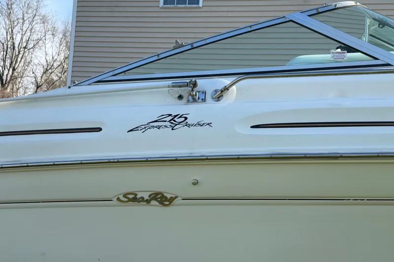 Slide: The Image of 2000 Sea Ray 215 Express Cruiser boat side view with logo and window detail. - 11