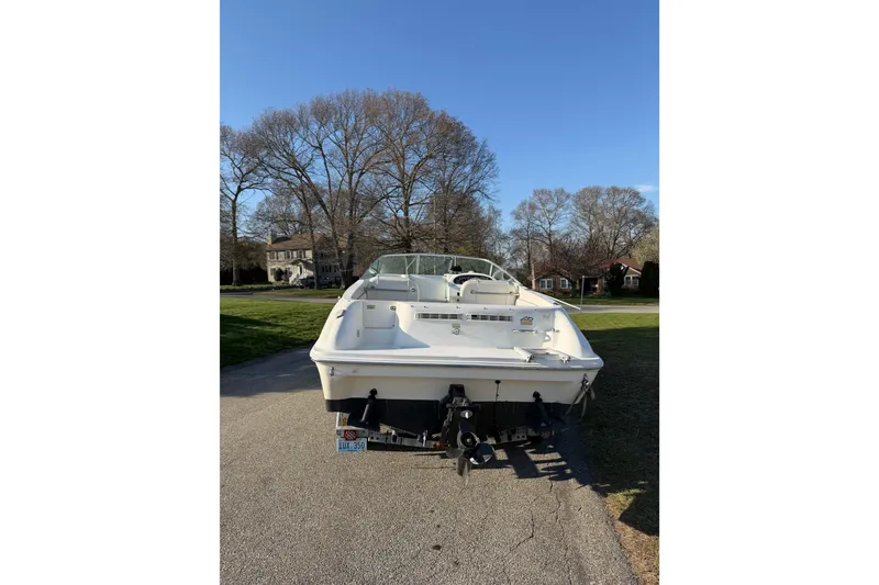 Slide: The Image of 2000 Sea Ray 215 Express Cruiser boat parked on a residential street. - 12