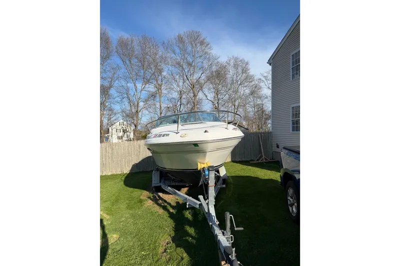 Slide: The Image of 2000 Sea Ray 215 Express Cruiser on trailer in residential yard. - 7