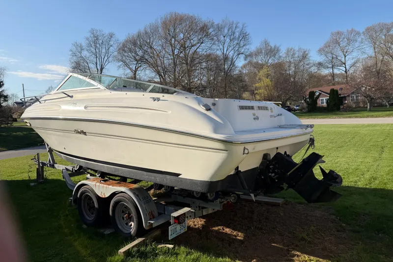 Slide: The Image of 2000 Sea Ray 215 Express Cruiser on trailer, parked on grass under clear sky. - 9